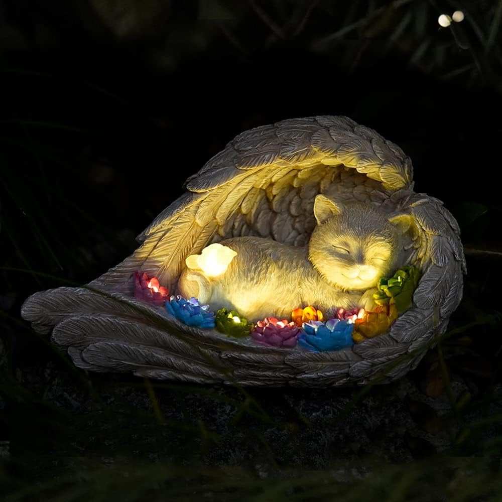 Dog memorial stone with solar angel statue for outdoor remembrance.