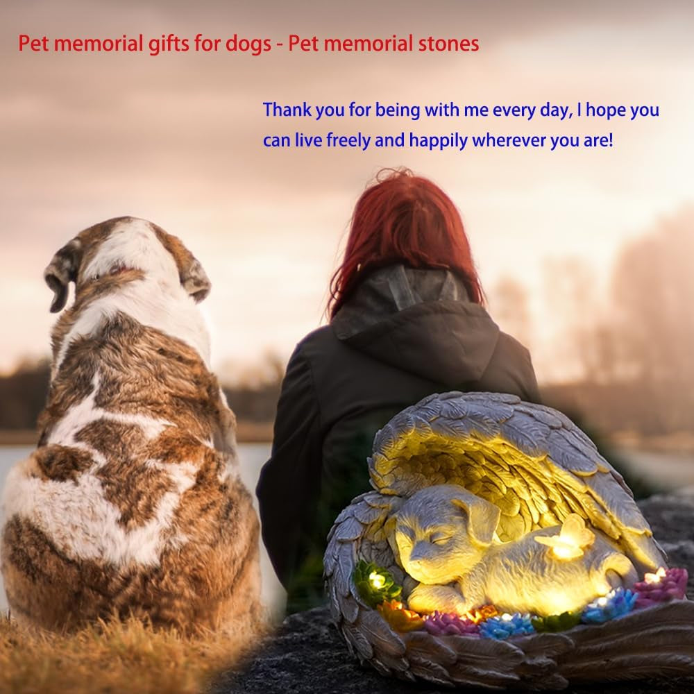 Dog memorial stone with solar angel statue for outdoor remembrance.