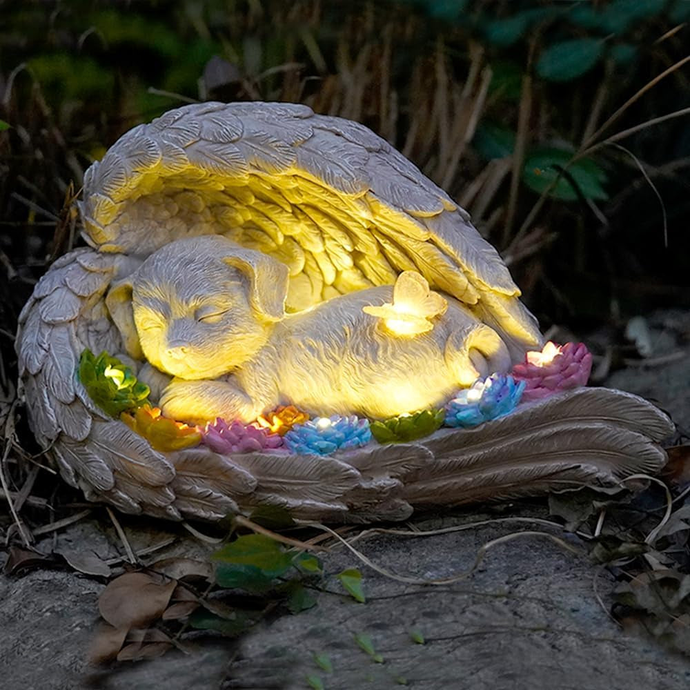 Dog memorial stone with solar angel statue for outdoor remembrance.